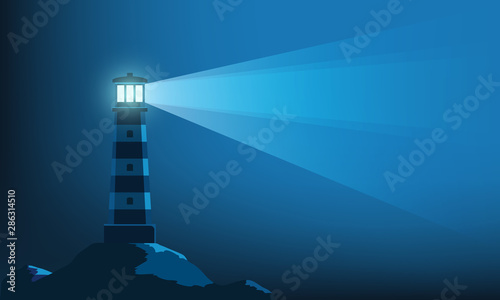 Lighthouse tower with a ray of light in the dark photo