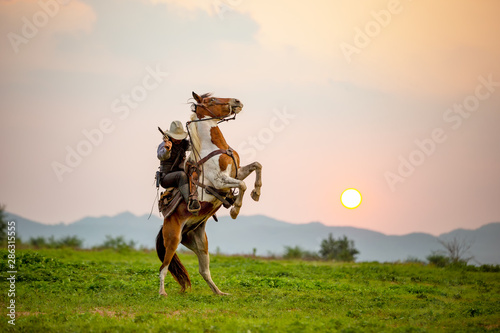 Fényképezés cowboy riding horse against sunset