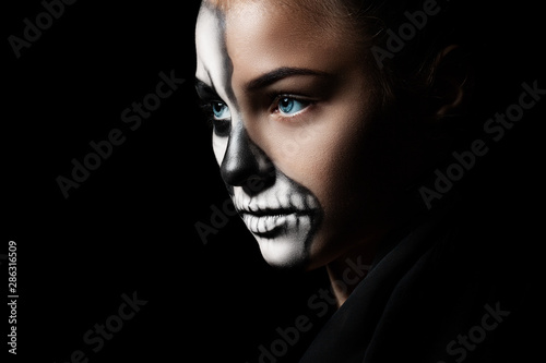 Halloween. Portrait of young beautiful girl with make-up skeleton on her face