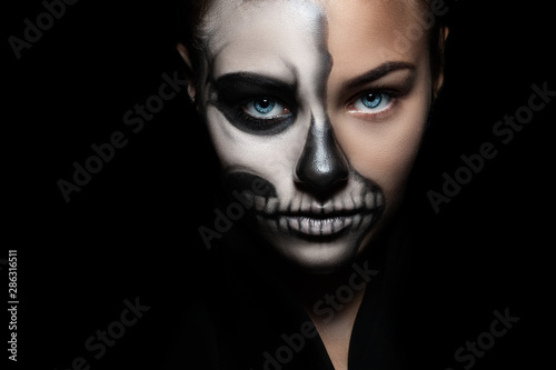 Halloween. Portrait of young beautiful girl with make-up skeleton on her face