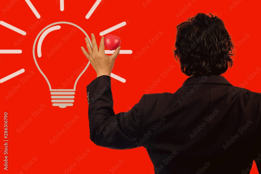 Business man holding red heart ball with light bulb.idea concept. Business man holding red heart ball with light bulb.idea concept.