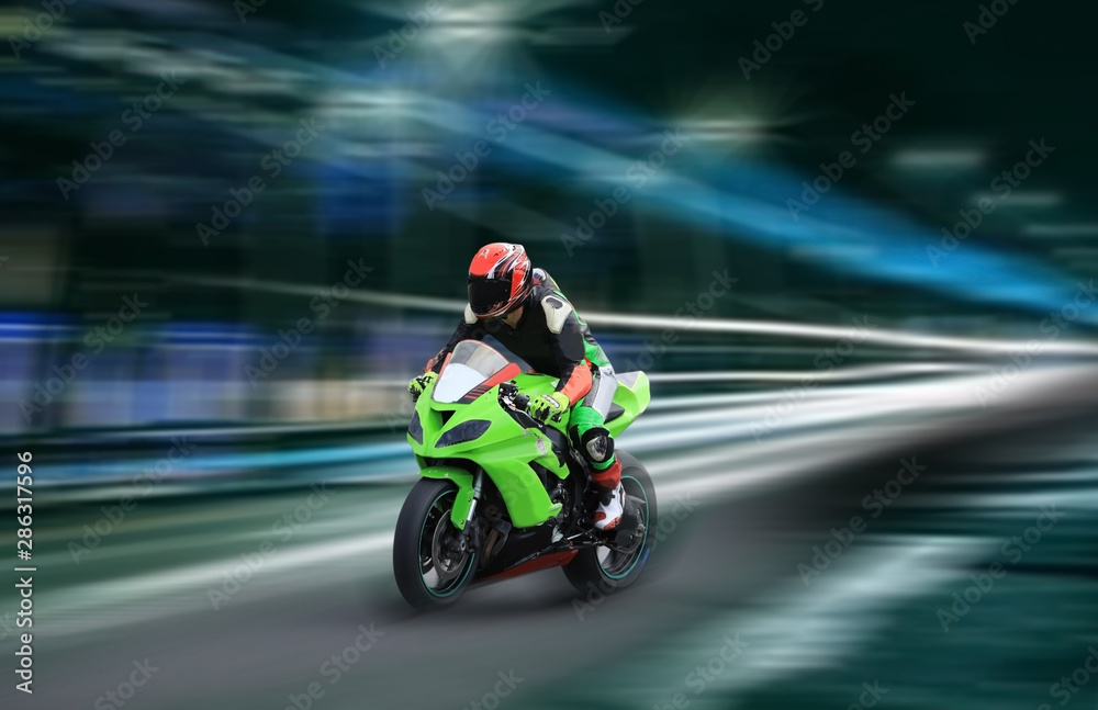 Motorcycle rider racing at high speed on the nighttime background