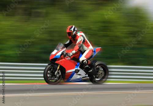Motorcycle rider racing at high speed on race track. Sports theme racing