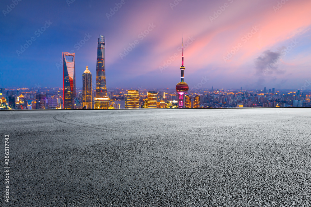 Shanghai skyline and modern buildings with empty race track at night,China.