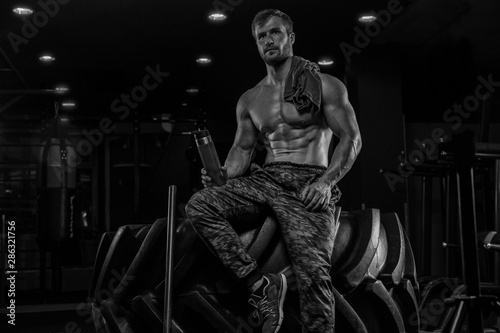 bodybuilder man, execute exercise with dumbbells, inside gym, horizontal photo