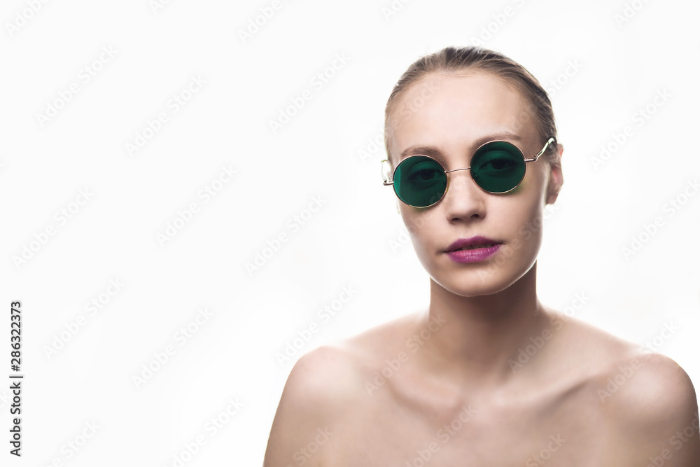 Fashion girl model in green sunglasses isolated on white background looking at the camera. Studio shot. Fashion girl model in green sunglasses isolated on white background looking at the camera. Studio shot.