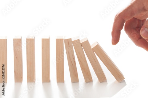 Hand Pushing Domino Pieces photo