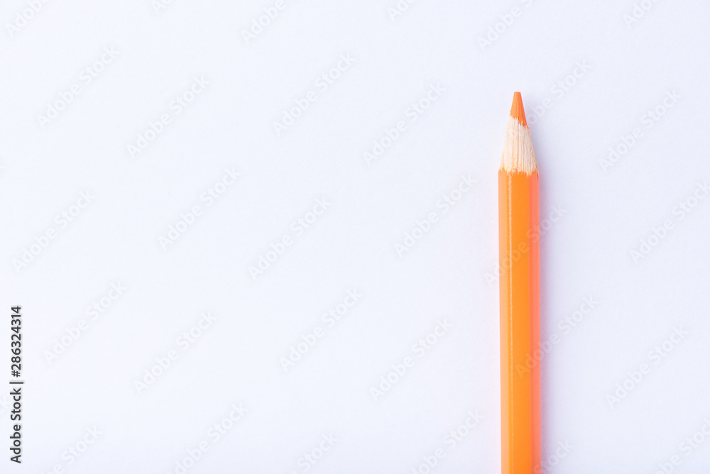 Macro photograph of several pencils of yellow and orange color on a white background Macro photograph of several pencils of yellow and orange color on a white background