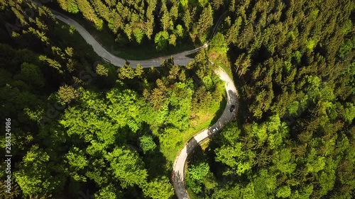 Drone shot, top view, above a road in the middle of slovenian mountains covered in forests photo