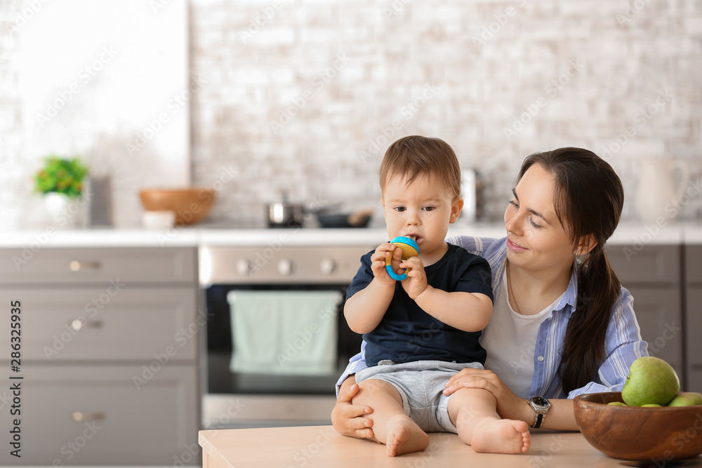 Mother and her little son with nibbler in kitchen at home Mother and her little son with nibbler in kitchen at home