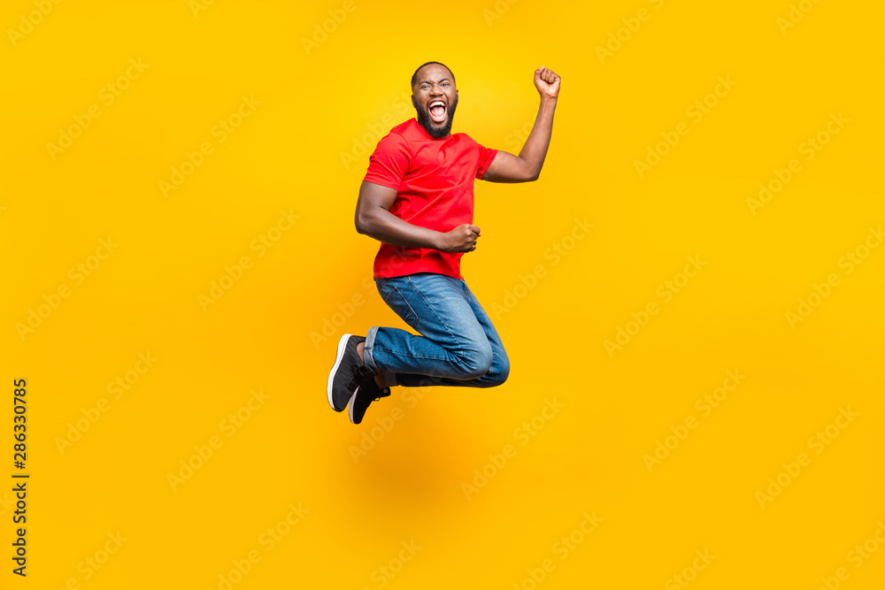 Full length body size photo of rejoicing overjoyed cheerful man who won some competitions at running while isolated with yellow background