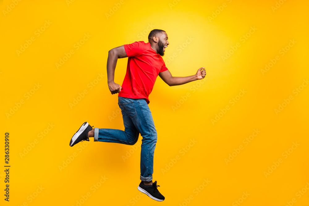 Full length body size photo of casual running man wearing jeans denim who aspires to achieve what he has planned while isolated with yellow background