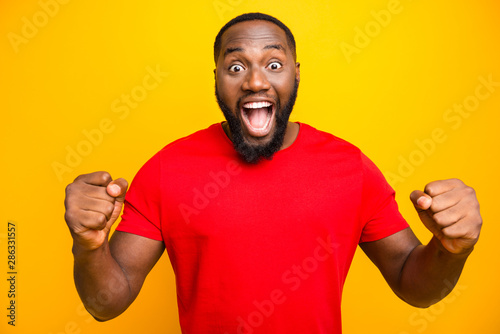 Photo of excited crazy black man having possibly won some contests end rejoicing with it while isolated with yellow background