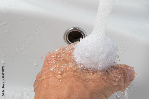 hand washing with soap on a white sink background, male hand