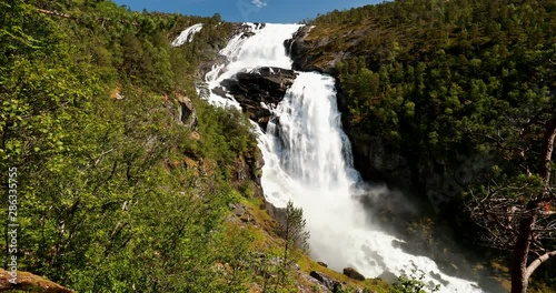 Kinsarvik, Hordaland, Norway. Waterfall Nyastolfossen In Hardangervidda Mountain Plateau. Nyastolsfossen in Spring Sunny Day. Height Of 115 m. Famous Landmark And Popular Destination. Panorama photo