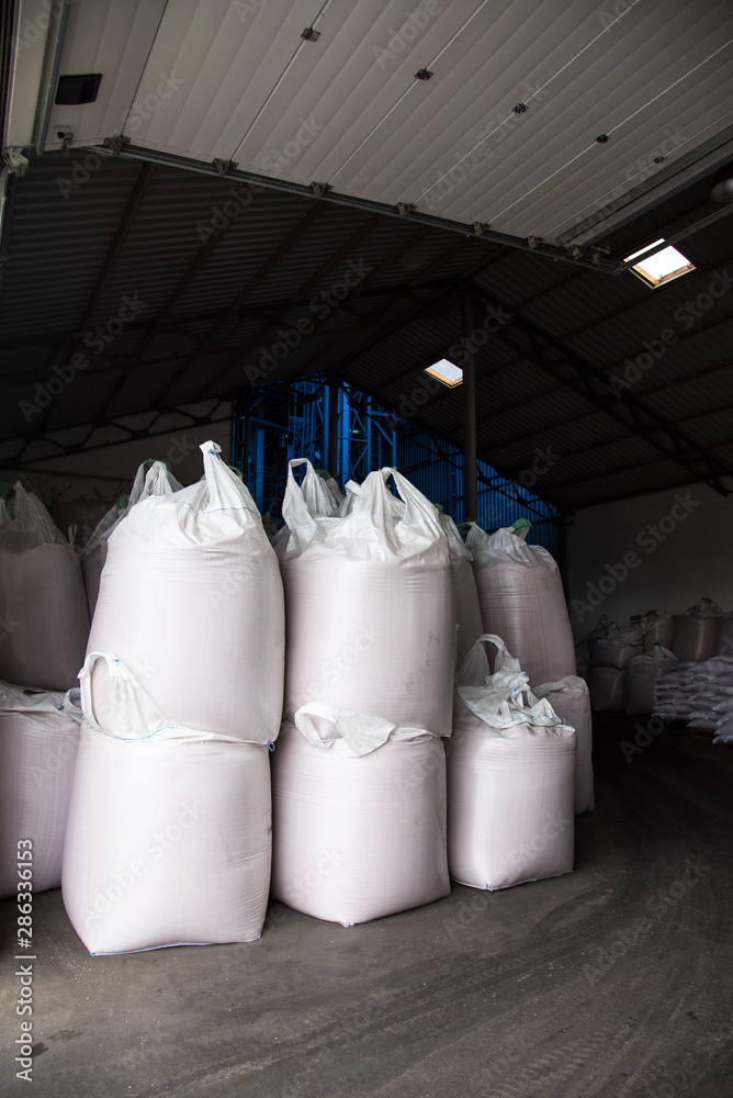 Abstract agrarian image with bags of grain in the agricultural sector in the farm. (good harvest, abundance - concept)