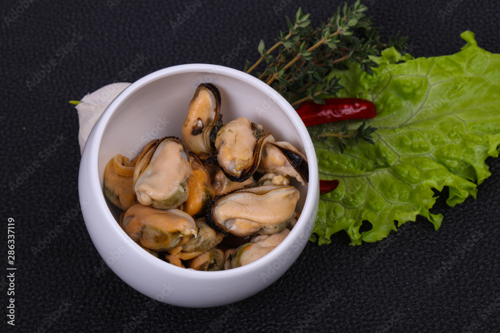 Pickled mussels in the bowl served pepper, garlic and salad Pickled mussels in the bowl served pepper, garlic and salad