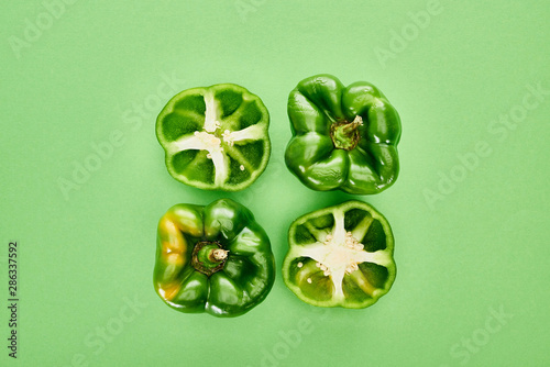 top view of fresh and organic peppers on green background