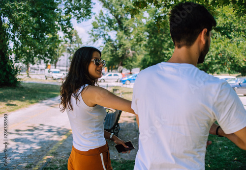 Beautiful loving couple walking together on a summer day in park photo