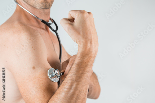 shirtless men with stethoscope on the arm