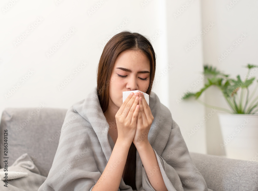 Asian young woman is sick, unwell, cold and have a flu symptoms on the sofa. Asian young woman is sick, unwell, cold and have a flu symptoms on the sofa.