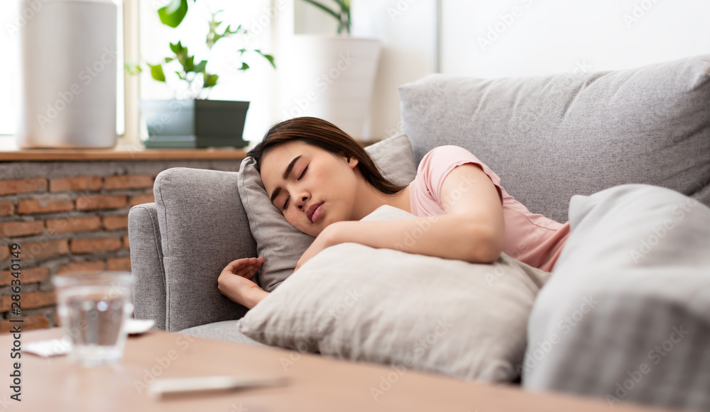 Asian young woman is sick, unwell, cold and sleep on the sofa. Asian young woman is sick, unwell, cold and sleep on the sofa.