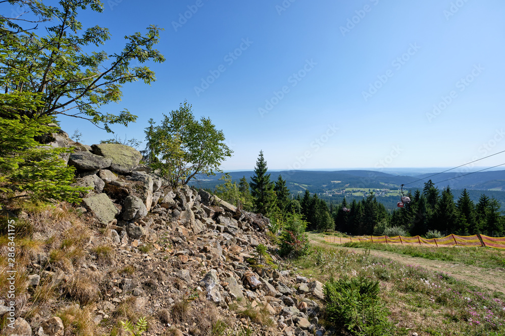 Beautiful scenic view into the landscape with rocks and stones from the top of the Ochsenkopf mountain in the Fichtel mountains in Germany into the southern direction