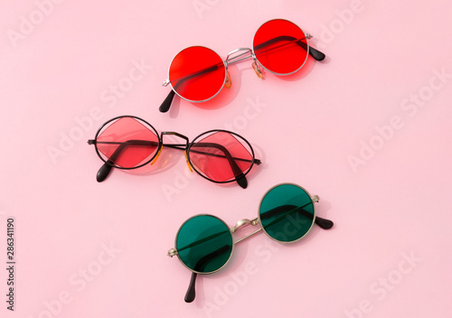 Vintage fashionable set of round sunglasses on pink background