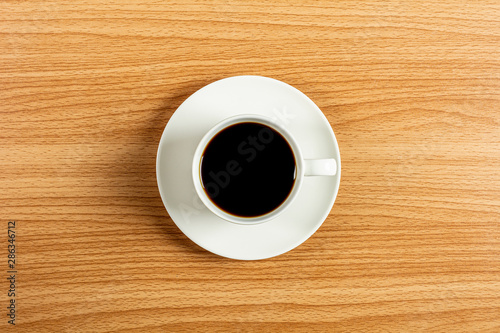 white ceramic coffee cup on wooden desk. - blank space for advertising text.