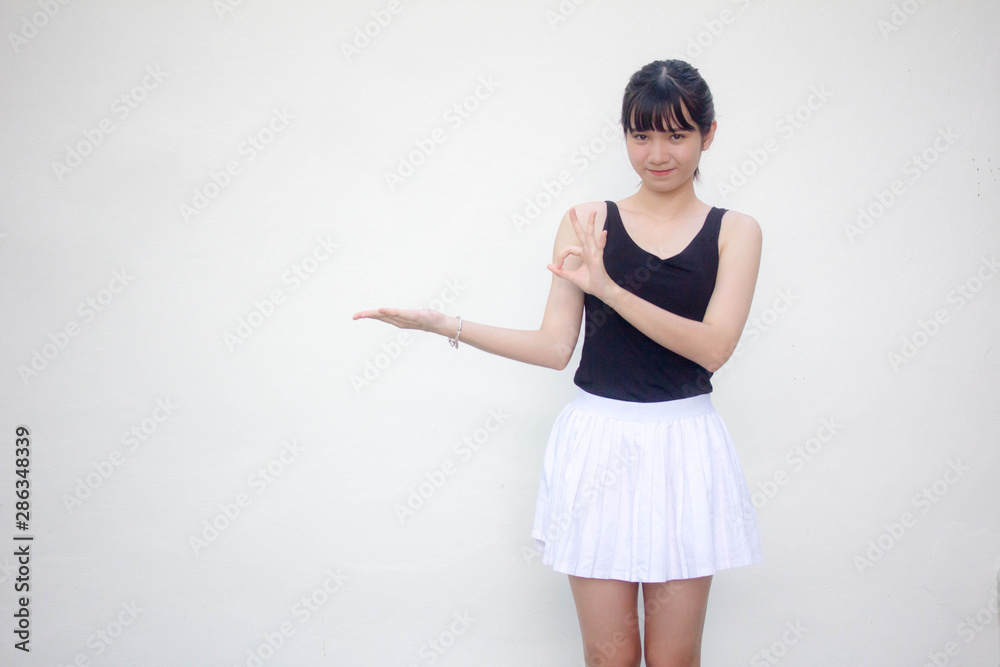 Portrait of thai adult beautiful girl black shirt white skirt show hand Portrait of thai adult beautiful girl black shirt white skirt show hand