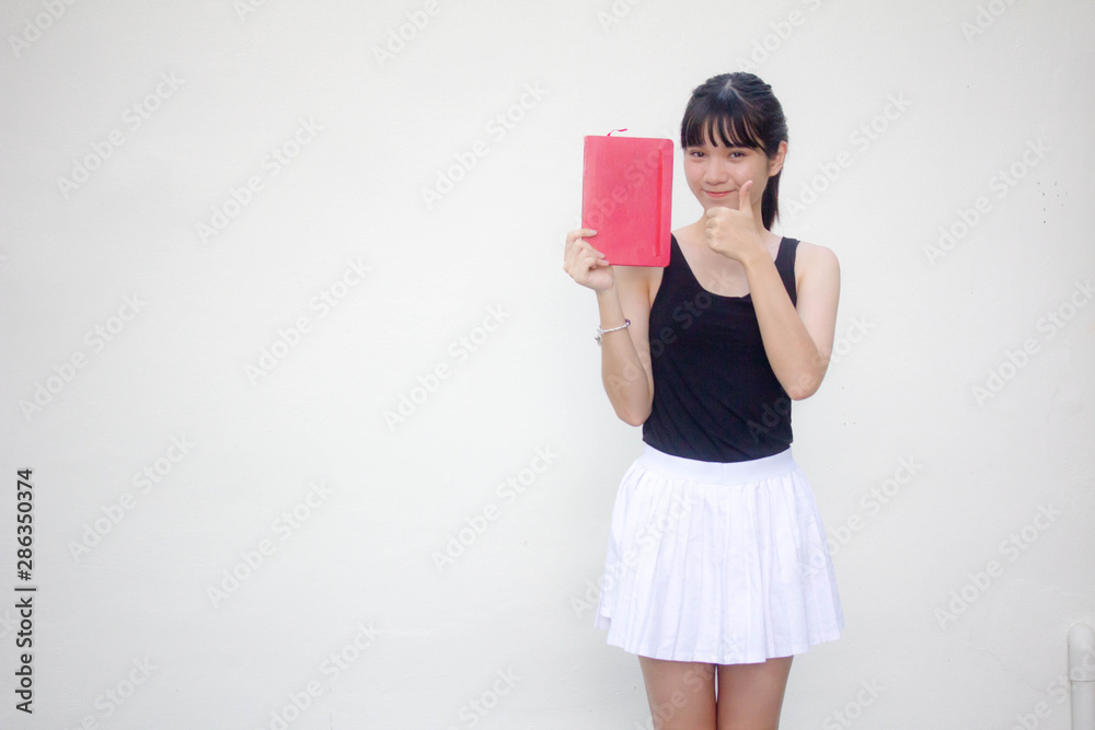 Portrait of thai adult beautiful girl black shirt white skirt and red book Portrait of thai adult beautiful girl black shirt white skirt and red book