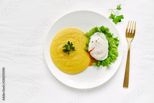 Poached egg and polenta with lettuce salad, fodmap diet, top view copy space closeup