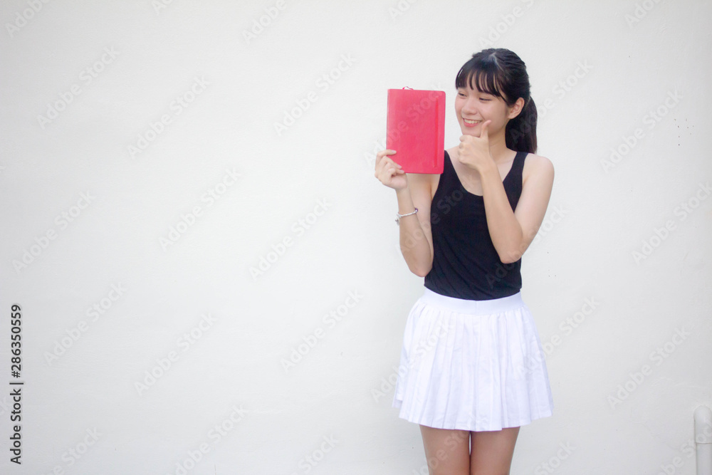 Portrait of thai adult beautiful girl black shirt white skirt and red book Portrait of thai adult beautiful girl black shirt white skirt and red book