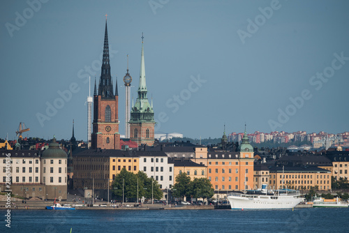 Stockholm buildings at the bay Riddarfjärden between the district Södermalm, Kunsholmen, Gamla Stan and Riddarholmen at sunset with a low sun and fogg torning up in the archipelago