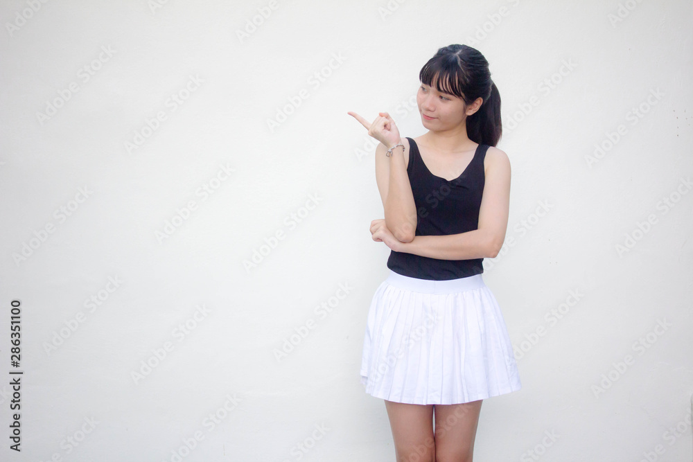 Portrait of thai adult beautiful girl black shirt white skirt pointing Portrait of thai adult beautiful girl black shirt white skirt pointing