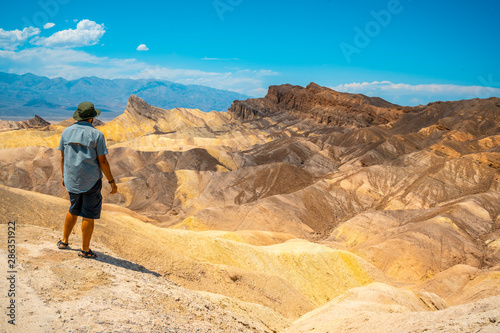 A man with a green shirt on the beautiful viewpoint of Zabriskre Point, California. United States