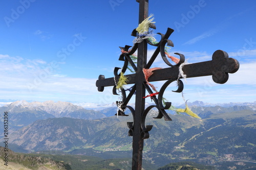 christian cross over a mountain against blue sky, cima cece, peak 