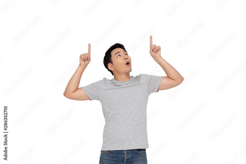 Portrait of a happy Asian young man pointing fingers up at copy space isolated over white background Portrait of a happy Asian young man pointing fingers up at copy space isolated over white background