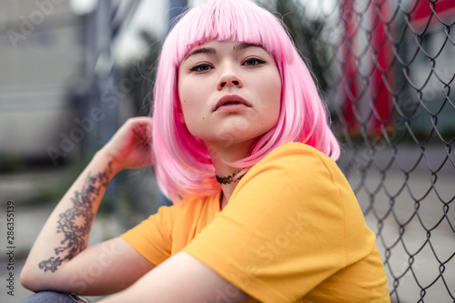 Valokuva Pretty young Asian woman with pink hair and tattoo