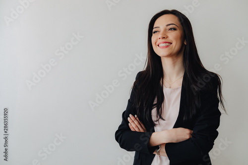 Young attractive emotional girl in business-style clothes on a plain white background in an office or audience