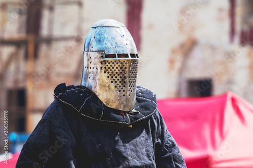 Medieval knight in helmet and dark clothing_