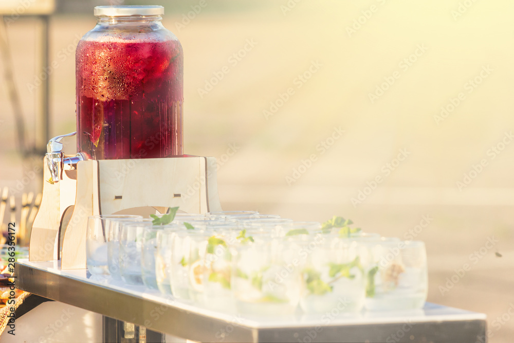 Decorative outdoor party drink station with small bottles and homemade peach lemonade