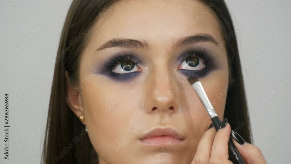 Young beautiful sexy girl models make blue evening makeup smoky eyes and with false eyelashes. Eyes with multi-colored contact lenses Young beautiful sexy girl models make blue evening makeup smoky eyes and with false eyelashes. Eyes with multi-colored contact lenses