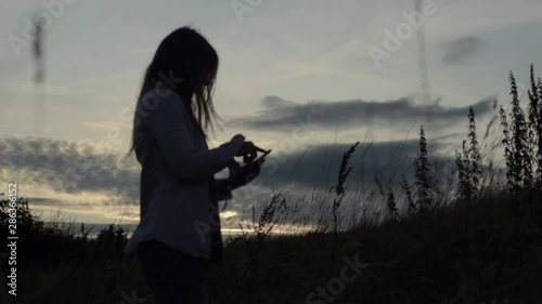 Wallpaper Mural Woman  using a cellphone in sunset landscape Torontodigital.ca