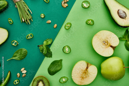 Obraz widok z góry na zielone warzywa i owoce: awokado, papryka, kiwi, zioła, jabłka