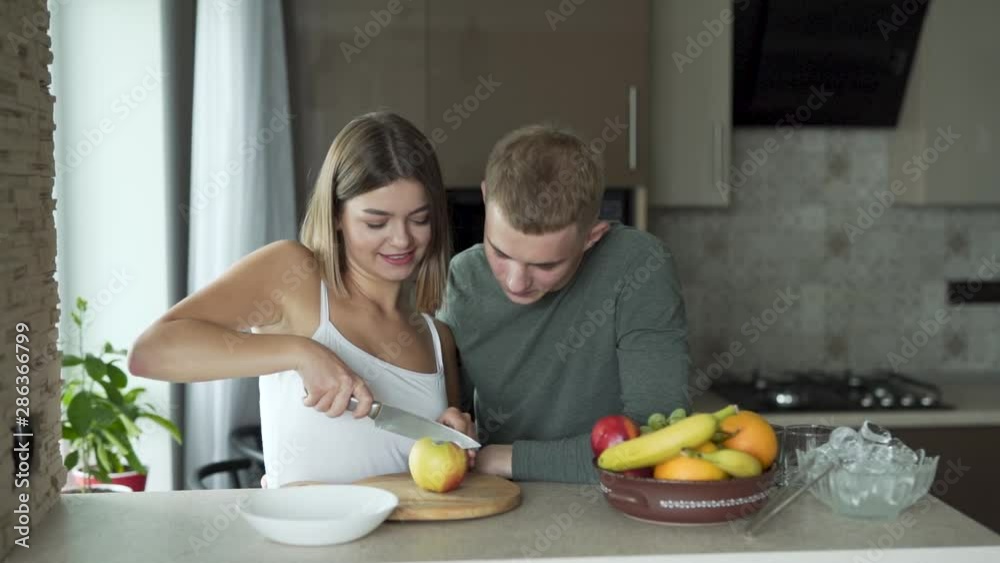 Couple of friends chopping an apple for an healthy fruit salad Couple of friends chopping an apple for an healthy fruit salad