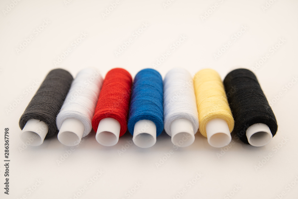 Set of sewing threads beautiful color (blue,yellow, green, white, black) on white background with space for text Set of sewing threads beautiful color (blue,yellow, green, white, black) on white background with space for text