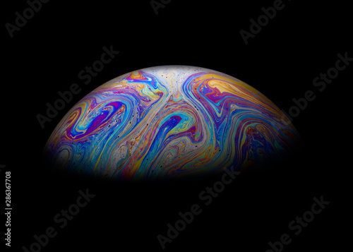 Abstract Soap bubble macro photo with black background look like planet