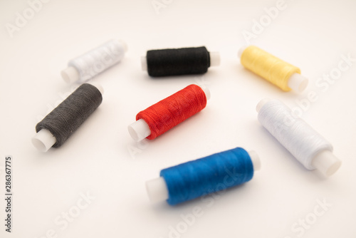 Set of sewing threads beautiful color (blue,yellow, green, white, black) on white background with space for text