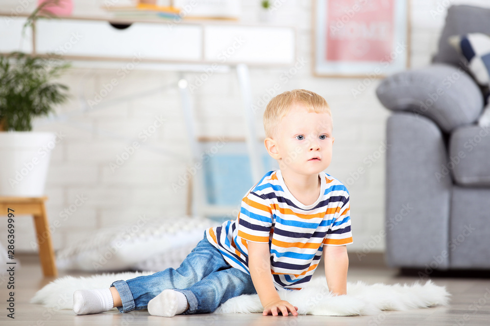Little boy sitting on white carpet at home Little boy sitting on white carpet at home